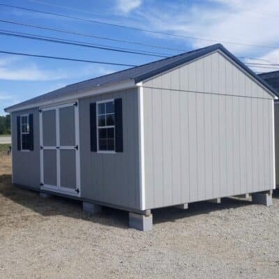 12 x 20 size painted a-roof style shed with gap gray siding, white trim, black metal roof, black shutters, ggs 6 foot doors, two windows.