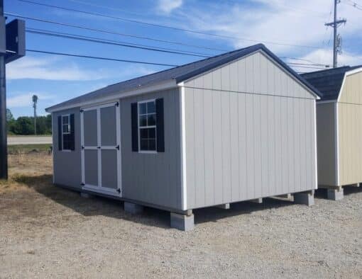 12 x 20 size painted a-roof style shed with gap gray siding, white trim, black metal roof, black shutters, ggs 6 foot doors, two windows.