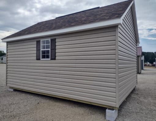 12x16 size vinyl garden roof style shed with clay siding, white trim, brownwood architectural shingle roof, brown shutters. has (1) 8' ridge vent, (1) octagon window, 6 foot fiber doors and two windows.