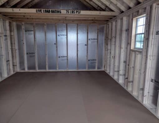 12x16 size vinyl garden roof style shed with clay siding, white trim, brownwood architectural shingle roof, brown shutters. has (1) 8' ridge vent, (1) octagon window, 6 foot fiber doors and two windows.
