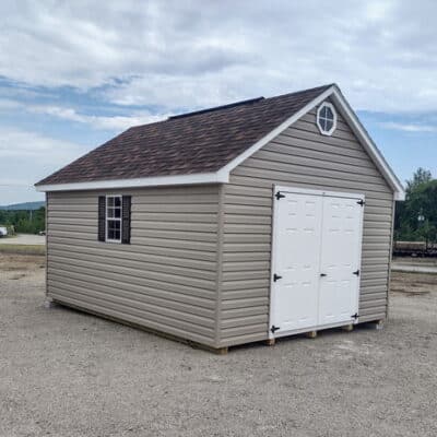 12x16 size vinyl garden roof style shed with clay siding, white trim, brownwood architectural shingle roof, brown shutters. has (1) 8' ridge vent, (1) octagon window, 6 foot fiber doors and two windows.