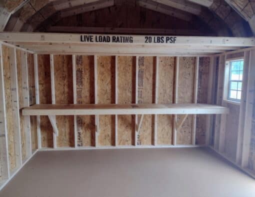 12x16 size vinyl high barn roof style shed with tan siding, white trim, brownwood architectural shingle roof, brown shutters. has 8' ridge vent, 6 foot fiber double doors and two windows.