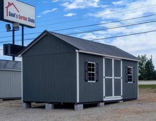 12 x 20 size painted classic garage style shed with gray siding, white trim, black metal roof, black shutters, garage door with glass, ggs 6 foot double doors 1' ft taller, two windows.