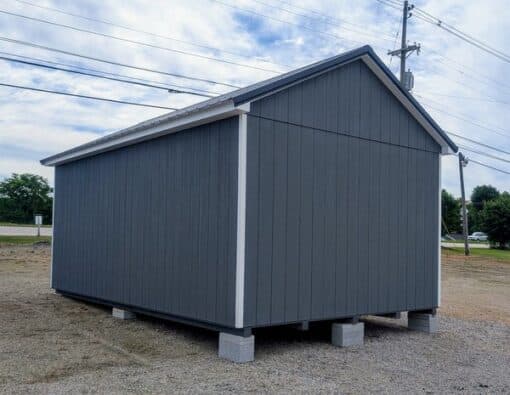 12 x 20 size painted classic garage style shed with gray siding, white trim, black metal roof, black shutters, garage door with glass, ggs 6 foot double doors 1' ft taller, two windows.