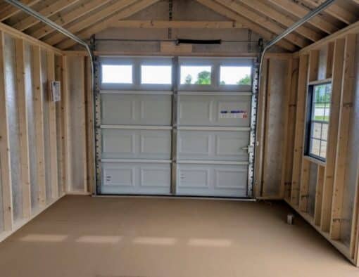 12 x 20 size painted classic garage style shed with gray siding, white trim, black metal roof, black shutters, garage door with glass, ggs 6 foot double doors 1' ft taller, two windows.