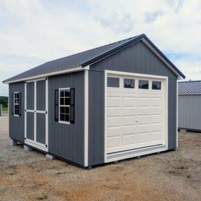 12 x 20 size painted classic garage style shed with gray siding, white trim, black metal roof, black shutters, garage door with glass, ggs 6 foot double doors 1' ft taller, two windows.