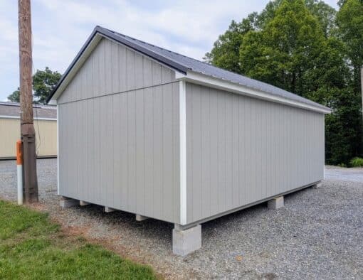 12 x 20 size painted classic style shed with gap gray siding, white trim, black metal roof, black shutters, ggs 6 foot doors, two windows.
