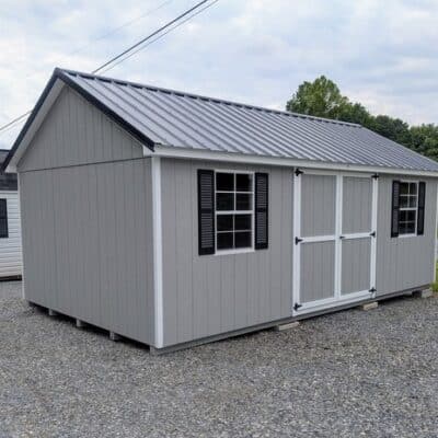 12 x 20 size painted classic style shed with gap gray siding, white trim, black metal roof, black shutters, ggs 6 foot doors, two windows.