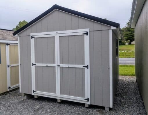 10 x 12 size painted a-roof style shed with gap gray siding, white trim, black metal roof, black shutters, ggs 6 foot doors, two windows.