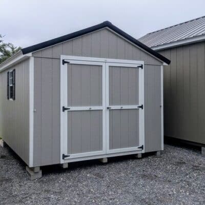 10 x 12 size painted a-roof style shed with gap gray siding, white trim, black metal roof, black shutters, ggs 6 foot doors, two windows.