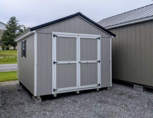 10 x 12 size painted a-roof style shed with gap gray siding, white trim, black metal roof, black shutters, ggs 6 foot doors, two windows.