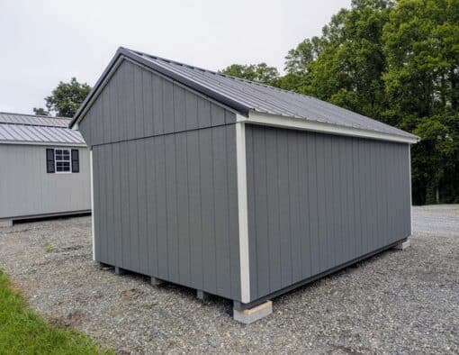 10 x 16 size painted carriage style shed with gray siding, white trim, black metal roof, black shutters, ggs 6 foot double doors, two windows.