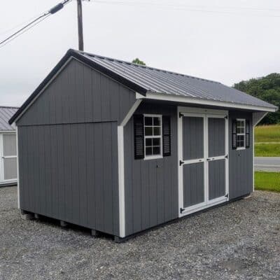 10 x 16 size painted carriage style shed with gray siding, white trim, black metal roof, black shutters, ggs 6 foot double doors, two windows.