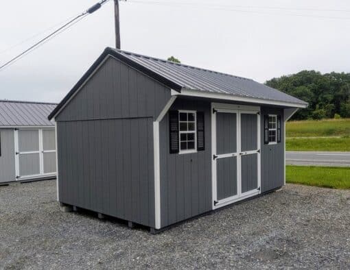 10 x 16 size painted carriage style shed with gray siding, white trim, black metal roof, black shutters, ggs 6 foot double doors, two windows.