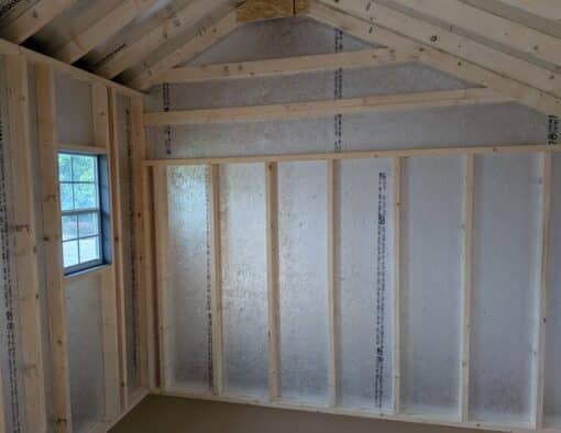 10 x 16 size painted carriage style shed with gray siding, white trim, black metal roof, black shutters, ggs 6 foot double doors, two windows.