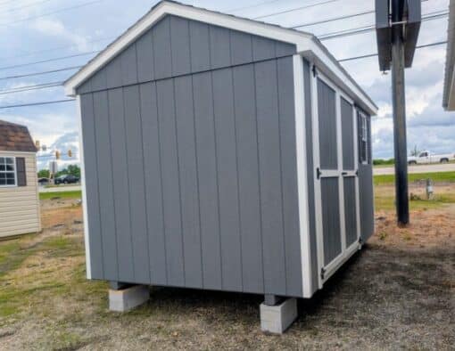 8 x 12 size painted a-roof style shed with gray siding, white trim, black architectural shingle roof, black shutters, (1) 8' ridge vent, ggs 6 foot double doors, one window.