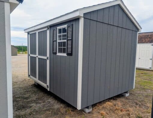 8 x 12 size painted a-roof style shed with gray siding, white trim, black architectural shingle roof, black shutters, (1) 8' ridge vent, ggs 6 foot double doors, one window.