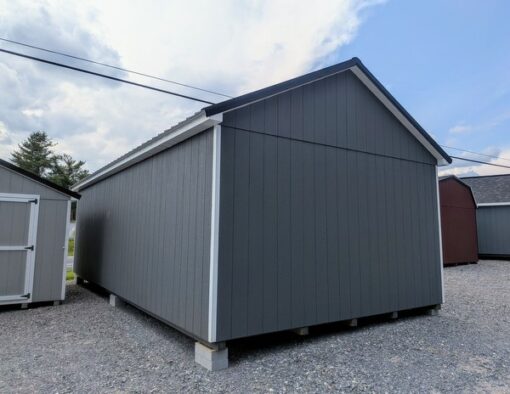 14 x 28 size painted classic garage style shed with gray siding, white trim, black metal roof, black shutters, garage door with glass, ggs 6 foot double doors 1' ft taller, two windows.