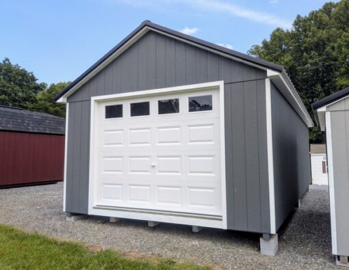 14 x 28 size painted classic garage style shed with gray siding, white trim, black metal roof, black shutters, garage door with glass, ggs 6 foot double doors 1' ft taller, two windows.