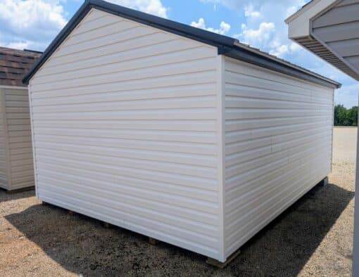 12x16 size vinyl a-roof style shed with white siding, black trim, black metal roof, black shutters. Has 6 foot fiber double doors and two windows.