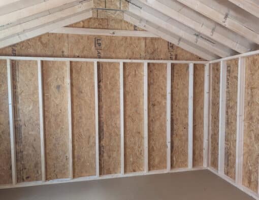 12x16 size vinyl a-roof style shed with white siding, black trim, black metal roof, black shutters. Has 6 foot fiber double doors and two windows.
