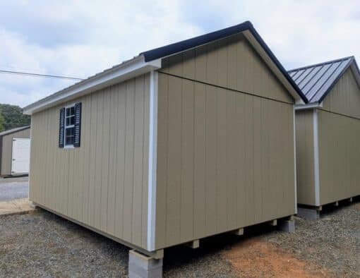 10 x 16 size painted classic style shed with tan siding, white trim, black metal roof, black shutters, ggs 6 foot double doors, two windows.