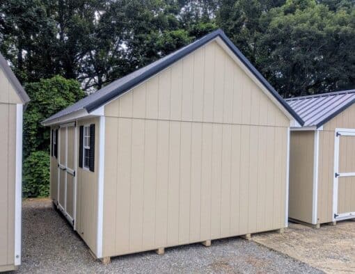 12 x 16 size painted garden style shed with leola almond siding, white trim, black metal roof, black shutters, ggs 6 foot double doors, two windows.