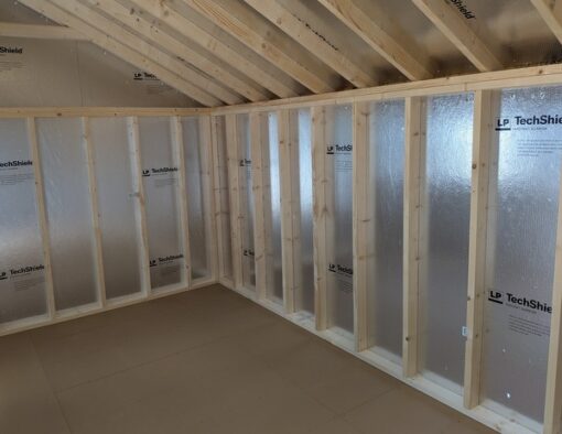 10x20 size vinyl carriage style shed with white siding, black trim, black metal roof, black shutters. Has 6 foot fiber 9 lite double doors and two windows and flower boxes.
