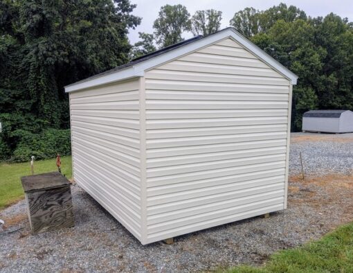 8x12 size vinyl a-roof style shed with pearl siding, white trim, black architectural shingle roof, black shutters. Has 8' ridge vent, 6 foot fiber double doors and one window.
