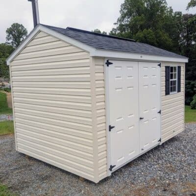 8x12 size vinyl a-roof style shed with pearl siding, white trim, black architectural shingle roof, black shutters. Has 8' ridge vent, 6 foot fiber double doors and one window.