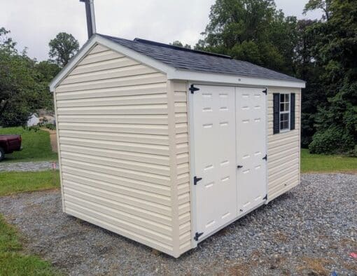 8x12 size vinyl a-roof style shed with pearl siding, white trim, black architectural shingle roof, black shutters. Has 8' ridge vent, 6 foot fiber double doors and one window.