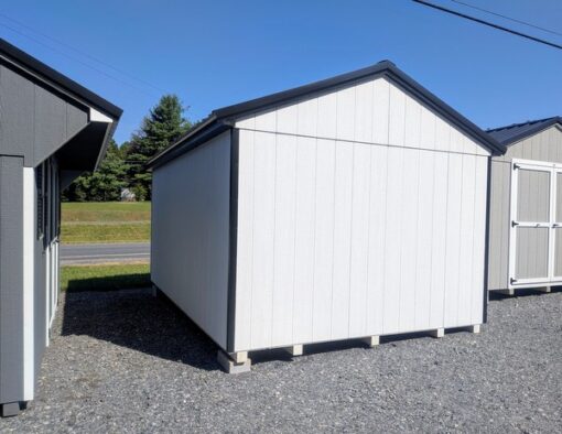 10 x 16 size painted a-roof style shed with white siding, black trim, black metal roof, black shutters, fiber solid 6 foot double doors, two windows.
