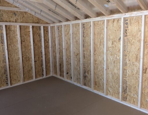 12x20 size vinyl a-roof style shed with white siding, white trim, black metal roof, black shutters. Has 6 foot fiber double doors and two windows.