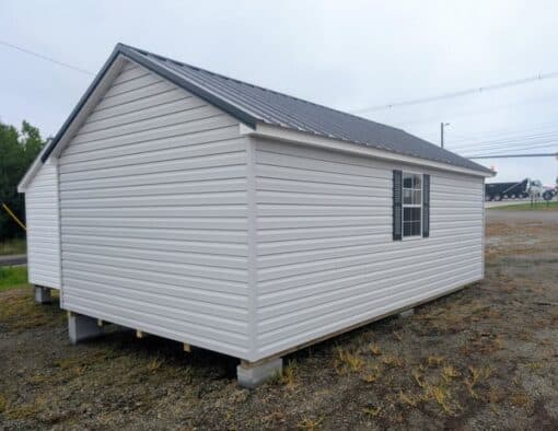 12 x 20 size vinyl classic style shed with gray siding, white trim, black metal roof, black shutters, fiber transom 6 foot double shed doors, two windows.
