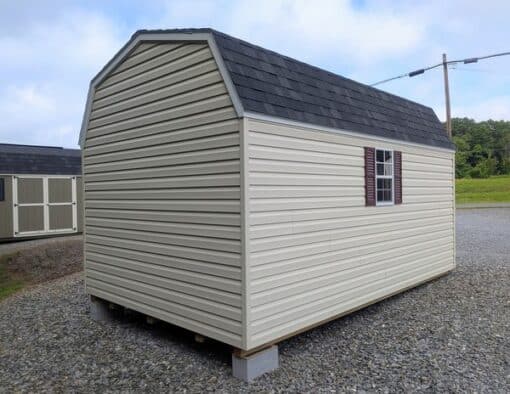 10x16 size vinyl high barn roof style shed with almond siding, white trim, black architectural shingle roof, burgundy shutters. has 8' ridge vent, 6 foot fiber double doors and two windows.