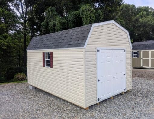 10x16 size vinyl high barn roof style shed with almond siding, white trim, black architectural shingle roof, burgundy shutters. has 8' ridge vent, 6 foot fiber double doors and two windows.