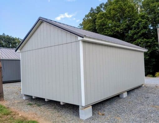 12 x 20 size painted classic style shed with gap gray siding, white trim, black metal roof, black shutters, ggs 6 foot doors, two windows.