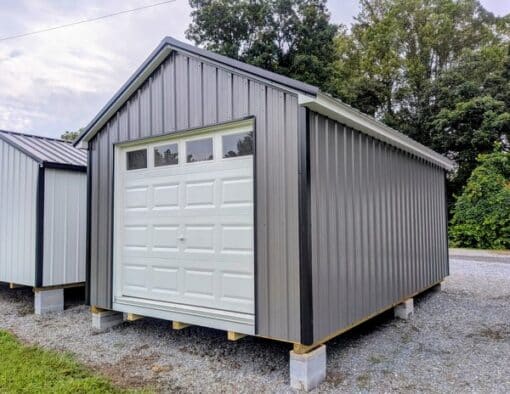 12x20 size metal classic garage style shed with white trim, charcoal metal siding, black metal roof, corners and j channel, 8x7 garage door with glass, 3 foot fiber solid shed door with two windows.