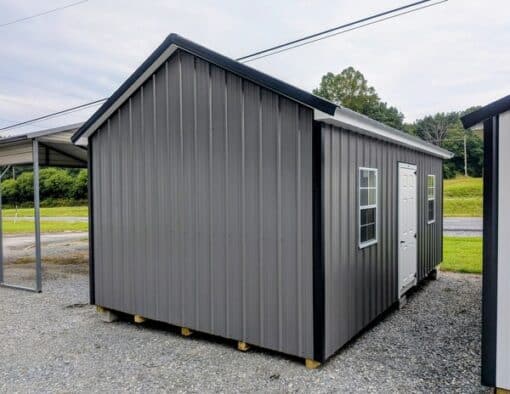 12x20 size metal classic garage style shed with white trim, charcoal metal siding, black metal roof, corners and j channel, 8x7 garage door with glass, 3 foot fiber solid shed door with two windows.