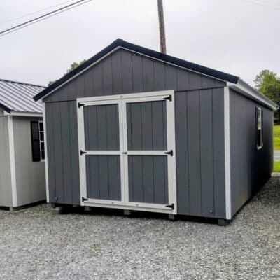 12 x 20 size painted a-roof style shed with gray siding, white trim, black metal roof, black shutters, ggs 6 foot double doors, two windows.