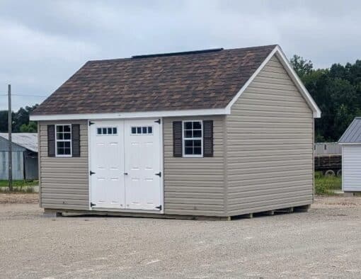 12x16 size vinyl garden roof style shed with clay siding, white trim, brownwood architectural shingle roof, brown shutters. has (1) 8' ridge vent, 6' foot fiber transom double doors and two windows.