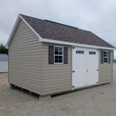 12x16 size vinyl garden roof style shed with clay siding, white trim, brownwood architectural shingle roof, brown shutters. has (1) 8' ridge vent, 6' foot fiber transom double doors and two windows.