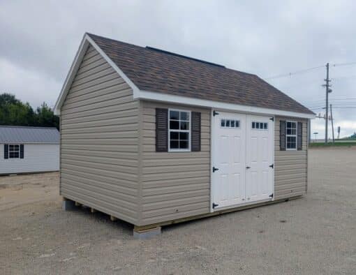 12x16 size vinyl garden roof style shed with clay siding, white trim, brownwood architectural shingle roof, brown shutters. has (1) 8' ridge vent, 6' foot fiber transom double doors and two windows.