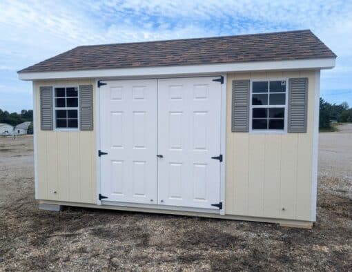 10 x 14 size painted classic style shed with navajo white siding, white trim, brownwood architectural shingle roof, clay shutters, fiber solid 6 foot double shed doors, two windows.