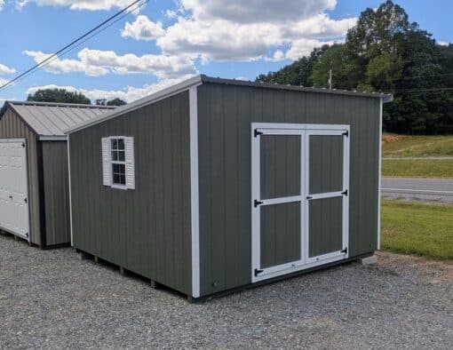 12x12 size painted economy style shed with avocado siding, white trim, alamo metal roof, white shutters, ggs 6 foot doors with two windows.