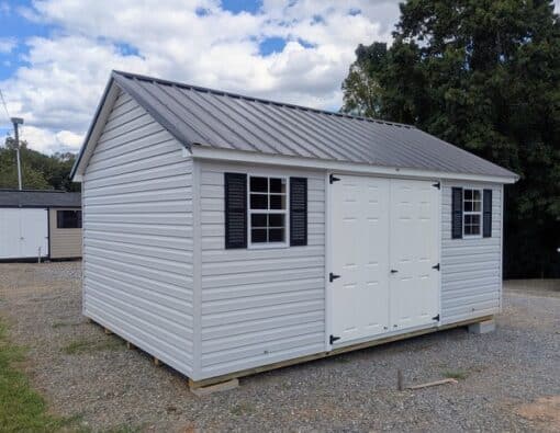 12 x 16 size vinyl classic style shed with gray siding, white trim, black metal roof, black shutters, fiber solid 6 foot double shed doors, two windows.