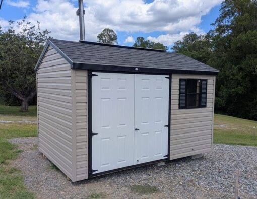 8x12 size vinyl a-roof style shed with clay siding, black trim, black architectural shingle roof, black shutters. Has 8' ridge vent, 6 foot fiber double doors and one black window.