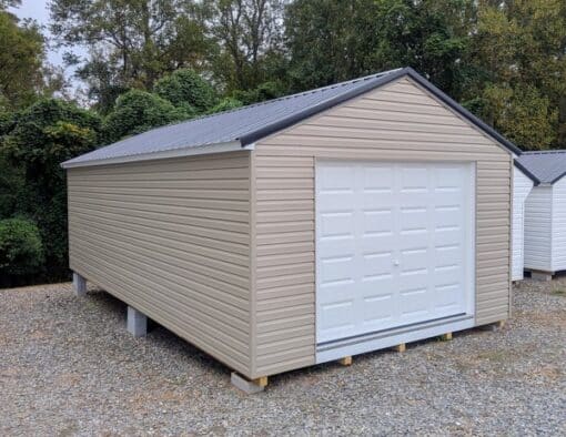 14 x 28 size vinyl a-roof garage style shed with clay siding, white trim, black metal roof, black shutters, 9x7 garage door, 6 foot fiber double doors with two windows.