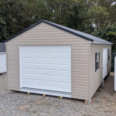 14 x 28 size vinyl a-roof garage style shed with clay siding, white trim, black metal roof, black shutters, 9x7 garage door, 6 foot fiber double doors with two windows.