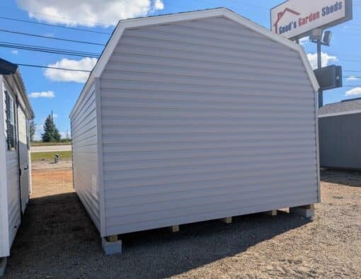 12x16 size vinyl high barn roof style shed with flint siding, white trim, estate gray architectural shingle roof, black shutters. has 8' ridge vent, 6 foot fiber double doors and two windows.